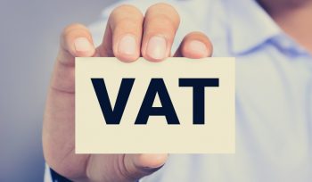 VAT letters (or Value Added Tax) on business card shown by a man
