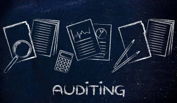 Blackboard with accounting instruments and the words auditing at the bottom