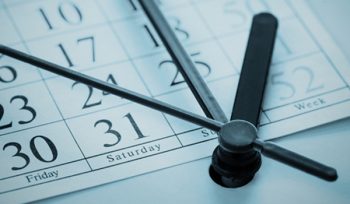 Clock hands ticking over a calendar